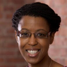 Gail smiling in front brick wall